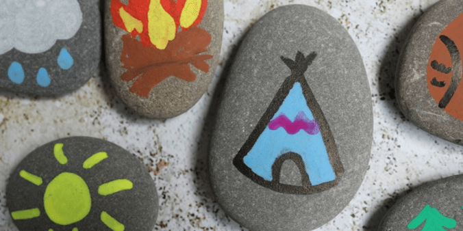 Painted stones with tents and bonfires and suns.